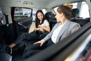 Two happy women at back seats in car
